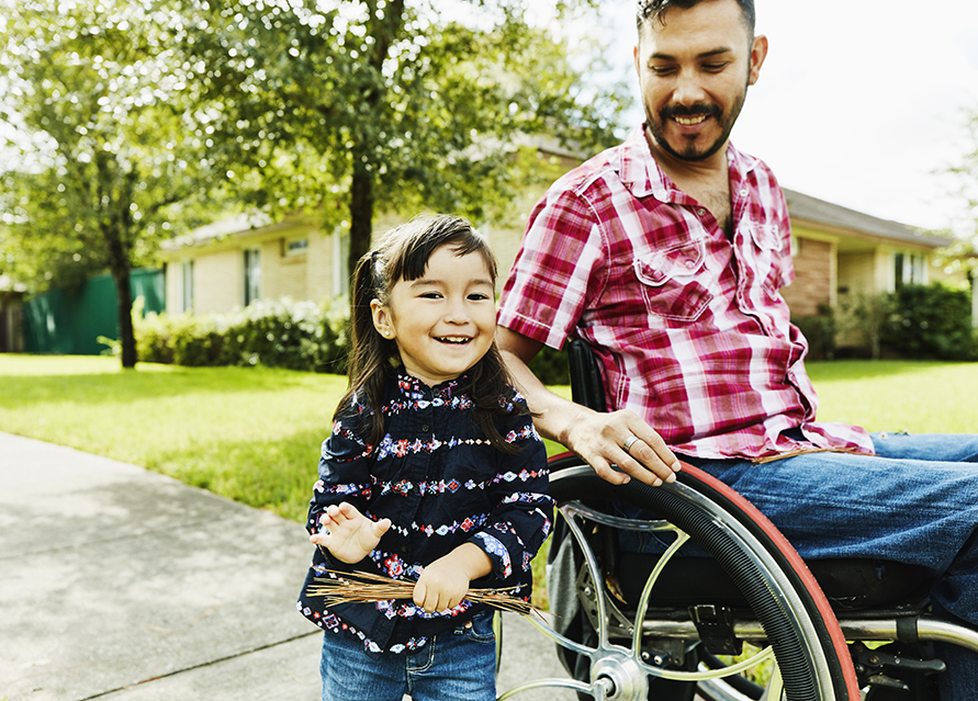 Man in wheelchair smiling at daughter